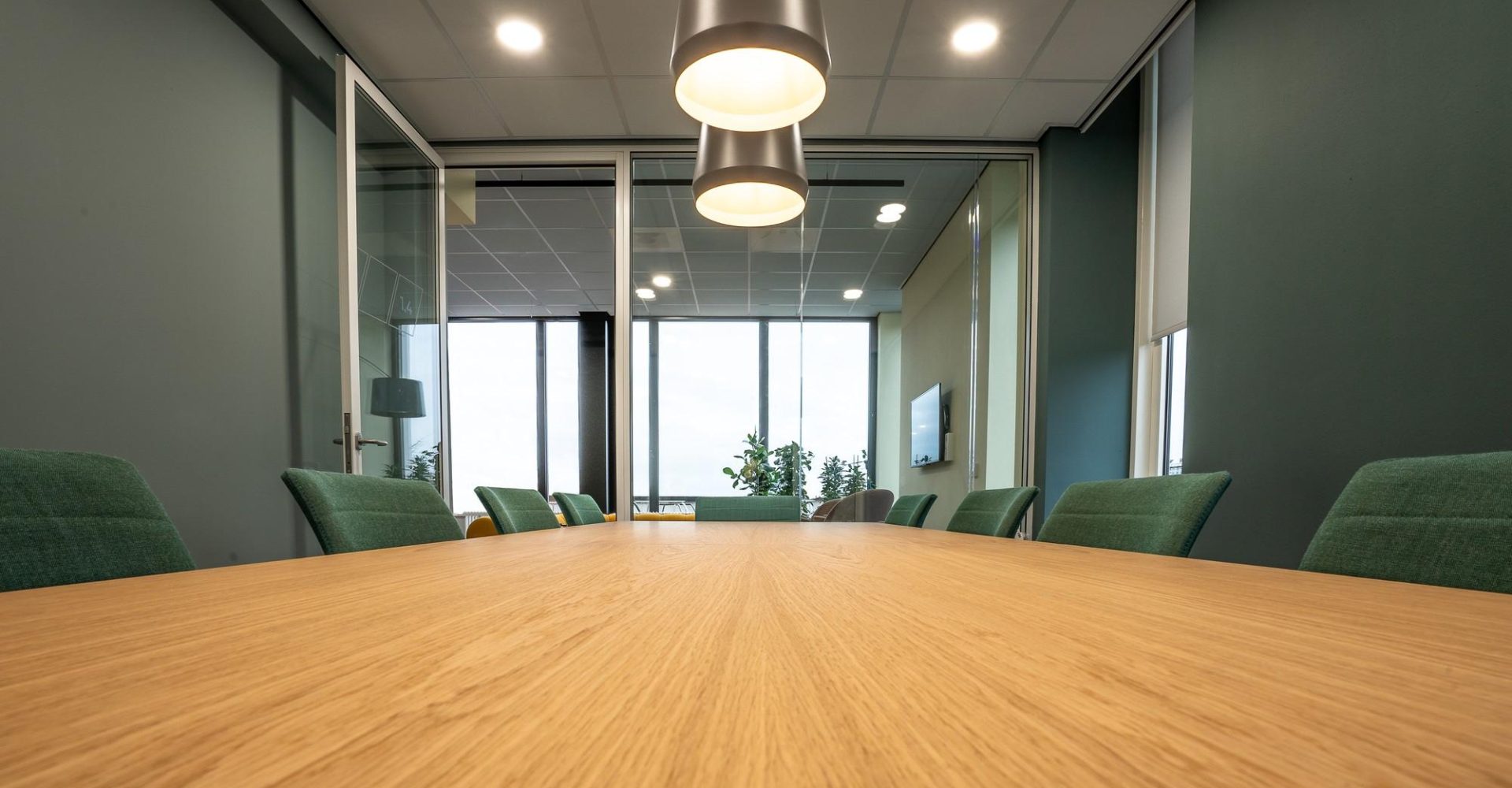 brown-table-surrounded-with-green-chairs-lamps-room (1)